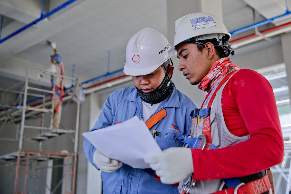 Bouwprofessionals bespreken werkzaamheden op een bouwplaats.